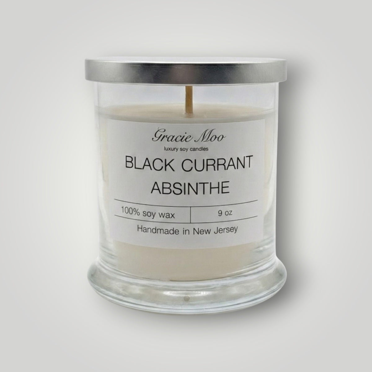 Black Currant Absinthe scented candle by Gracie Moo Candles, featuring a black candle with a smooth surface and elegant label.
