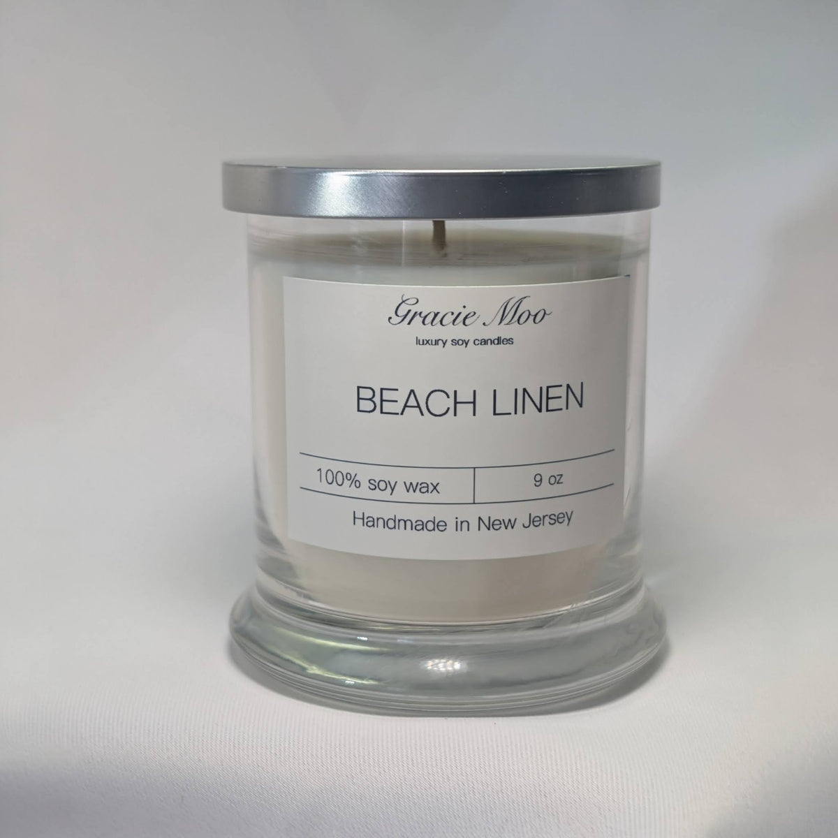 Beach Linen Status Candle by Gracie Moo Candles, featuring a tall, elegant candle in a glass holder with a beach-inspired scent.