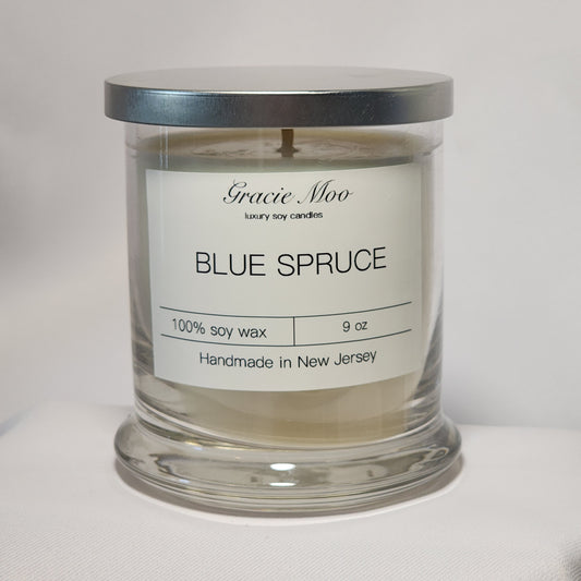 Blue Spruce Status Candle by Gracie Moo Candles featuring a tall, elegant candle with a fresh spruce scent and a blue-green hue.