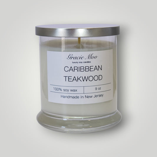 Caribbean Teakwood Status Candle by Gracie Moo Candles, featuring a tall wooden candle with a natural finish and a flickering flame.