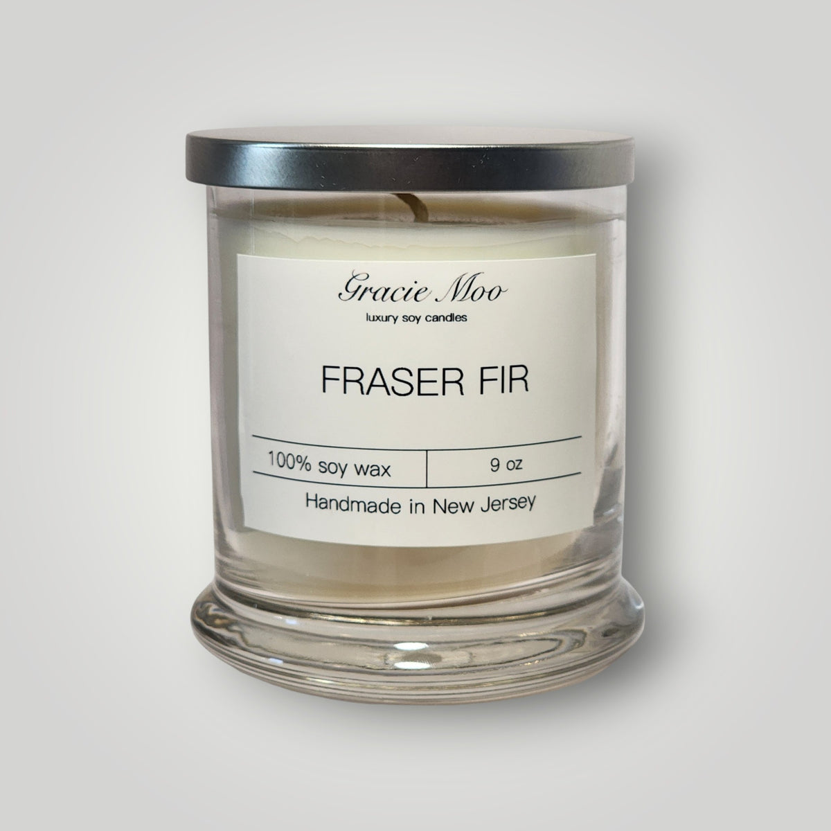 Gracie Moo Candles Fraser Fir Status Candle with realistic fir tree scent in a sleek glass container.