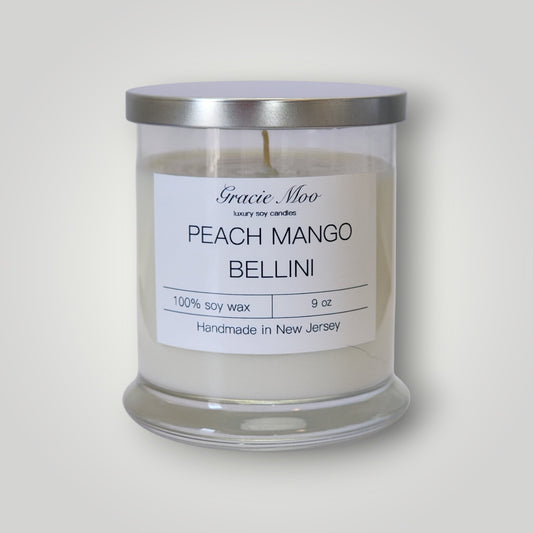Gracie Moo Candles Peach Mango Bellini scented candle with a stylish glass container and a peach and mango fragrance theme