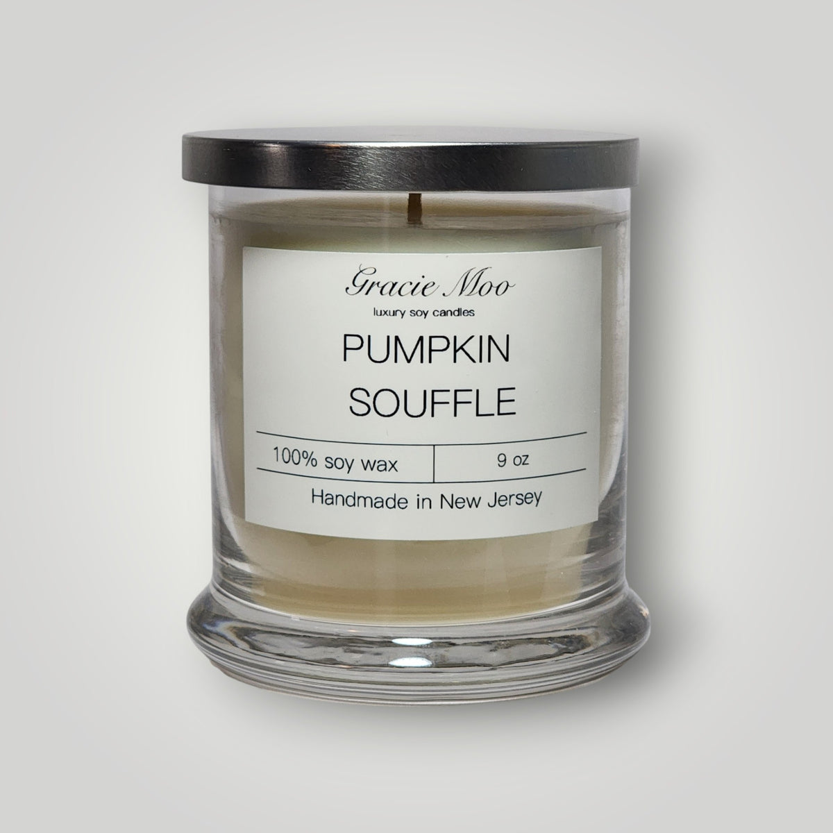 Pumpkin Soufflé scented candle by Gracie Moo Candles in a glass jar with a pumpkin-themed label.