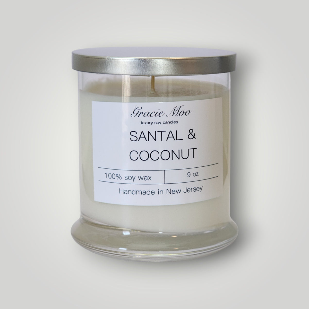 Gracie Moo Candles Santal & Coconut scented candle with a sleek glass jar, showcasing a warm, inviting interior design.