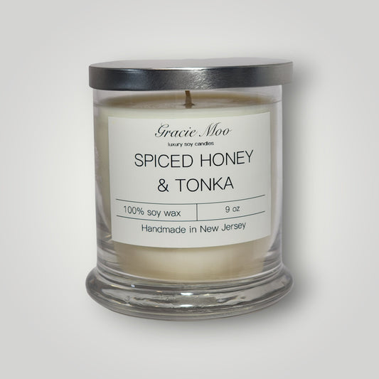 Gracie Moo Candles Spiced Honey & Tonka scented candle with warm, inviting glow and decorative candle holder.