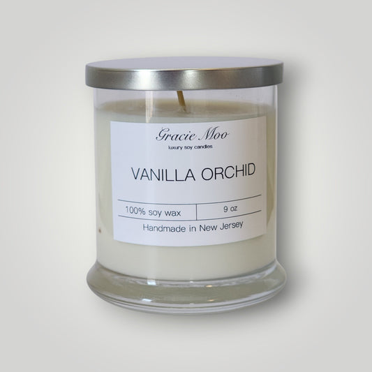 Vanilla Orchid Status Candle by GracieMoo Candles featuring a sleek white candle with subtle vanilla and orchid fragrance elements.